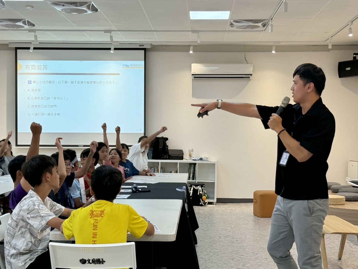 Students raising their hands during a sport and brain science session at Wenfu Elementary School